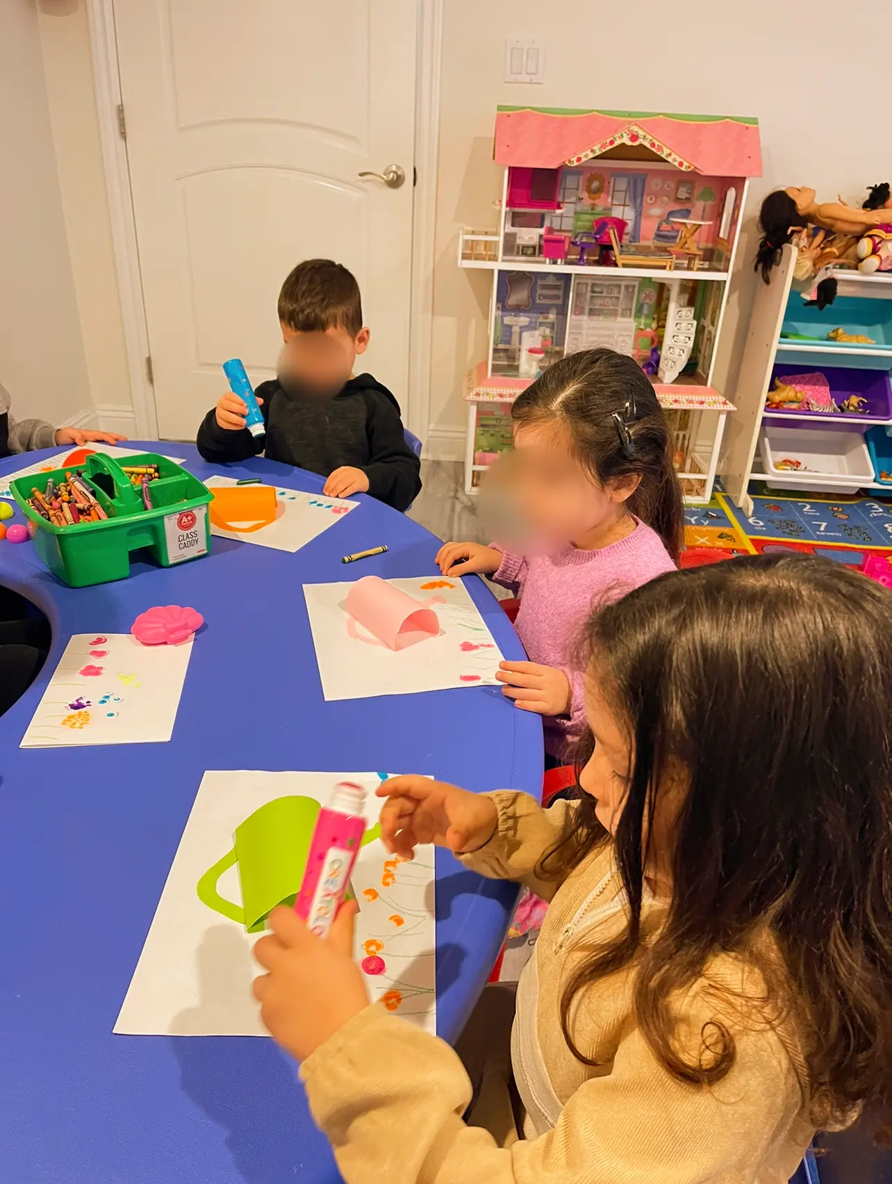 Children coloring and building paper crafts at a blue activity table