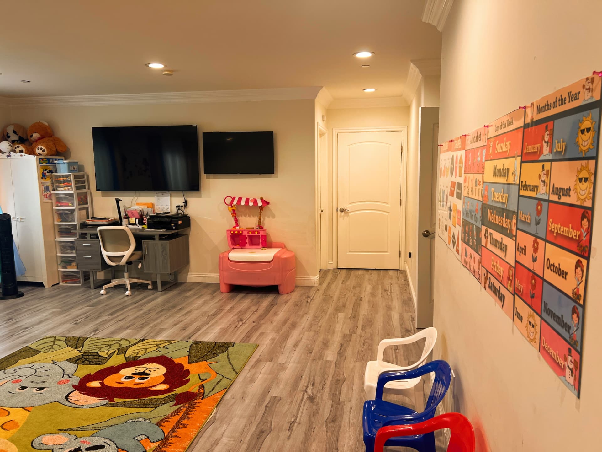 Bright indoor learning room with a play rug, calendar wall, and learning charts