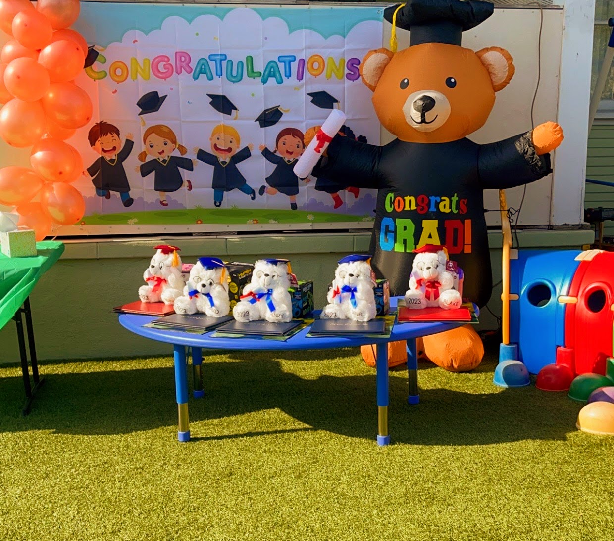 Graduation table with diplomas, teddy bears in caps, and a Congratulations banner