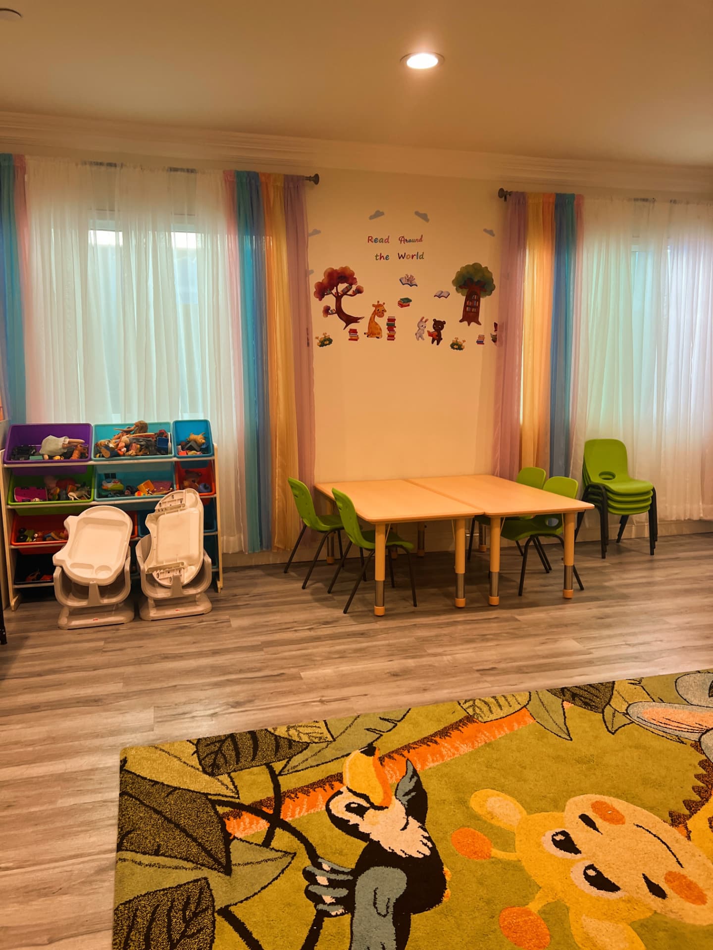 Learning room with a Read Around the World wall, toy bins, and a low activity table